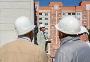 men in hardhats standing in front of building